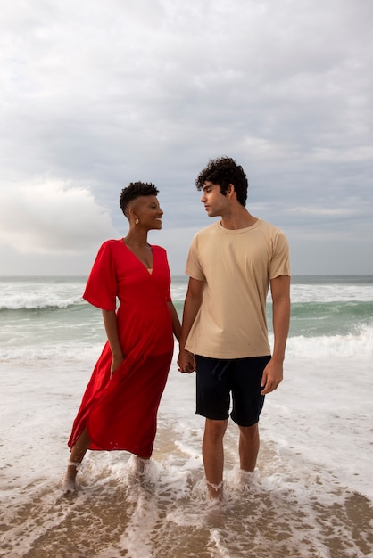 Casal romântico mostrando carinho na praia perto do oceano