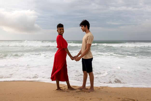Casal romântico mostrando carinho na praia perto do oceano