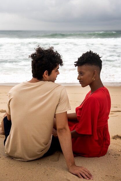 Casal romântico mostrando carinho na praia perto do oceano