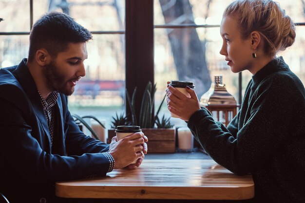 Casal romântico no café está tomando café e conversando. Homem bonito e linda garota gostando de estar juntos.