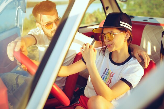 Casal romântico rindo sentado no carro durante uma viagem em um dia de verão