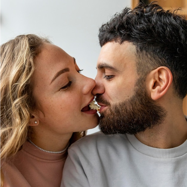 Casal romântico se beijando com pipoca em casa