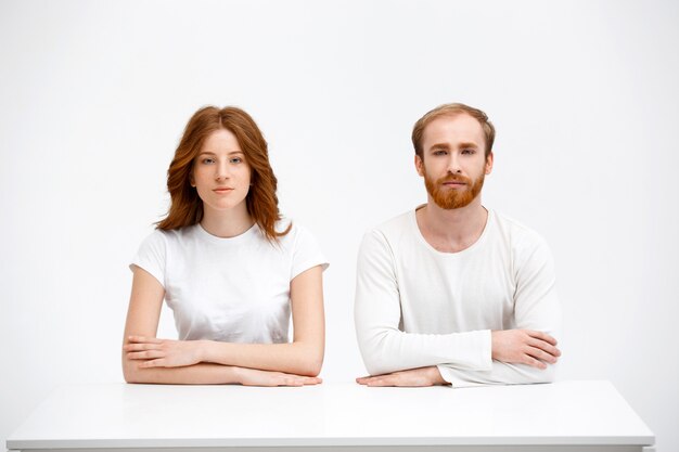 Casal ruiva senta como estudantes sobre a mesa