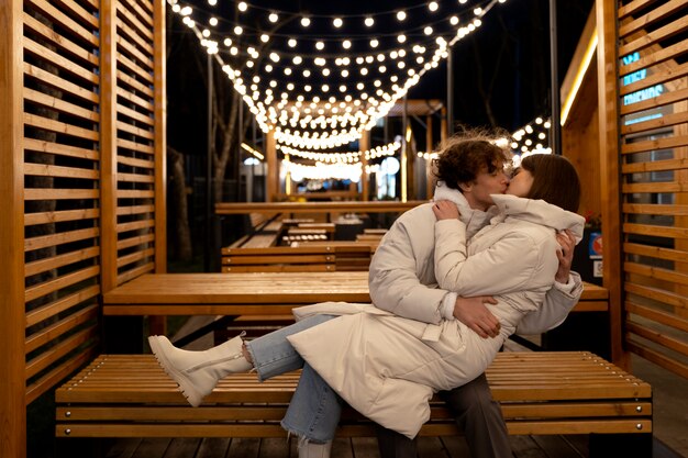 Casal se beijando ao ar livre enquanto se abraçava