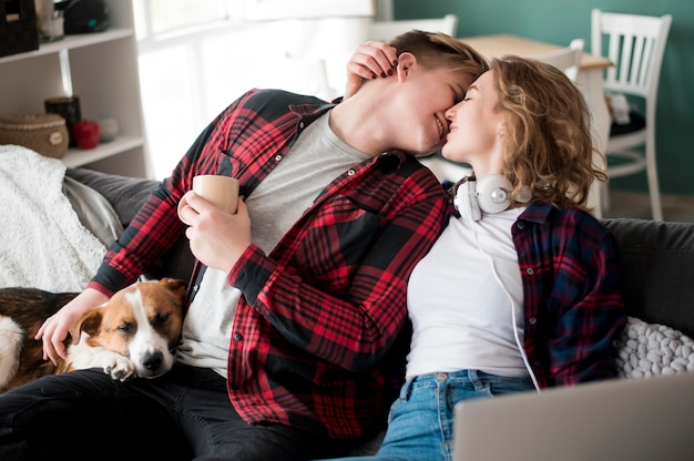 Casal se beijando ao lado de cachorro