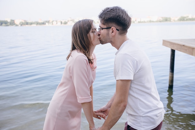 Casal se beijando com o mar ao fundo