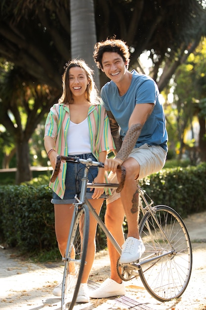 Casal se divertindo ao ar livre com uma bicicleta