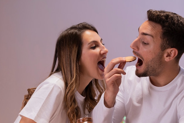 Foto grátis casal se divertindo com biscoitos