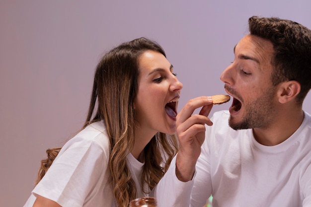 Casal se divertindo com biscoitos