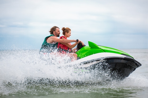 Foto grátis casal se divertindo na atividade marítima de verão de scooter aquático