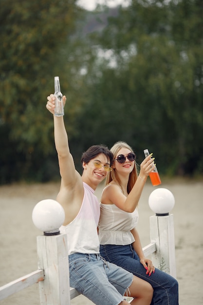 Casal se divertindo na praia com bebidas