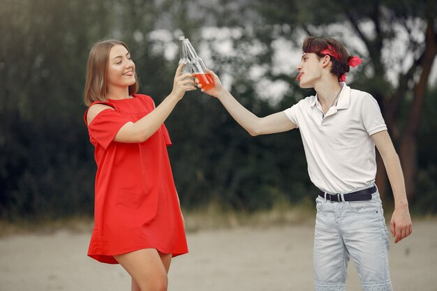 Casal se divertindo na praia com bebidas