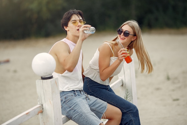 Foto grátis casal se divertir na praia com bebidas