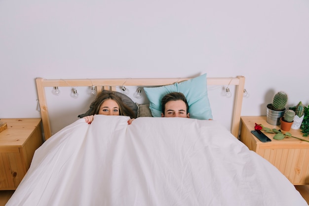 Foto grátis casal se esconde debaixo do cobertor