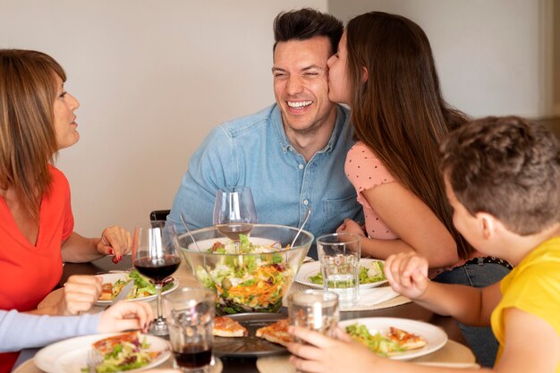 Casal sendo romântico em jantar em família