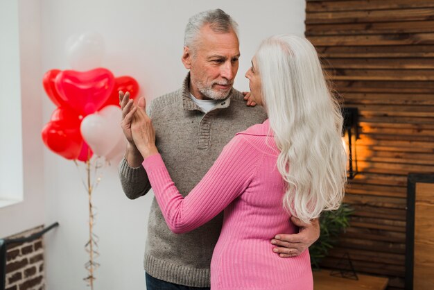 Casal sênior dançando em casa