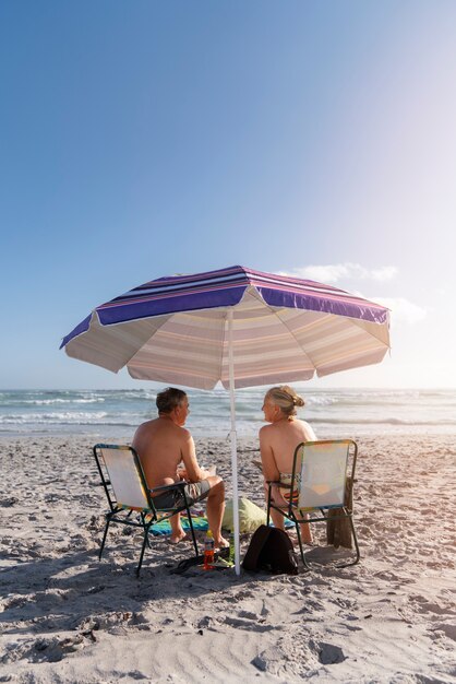 Casal sênior de tiro completo na praia