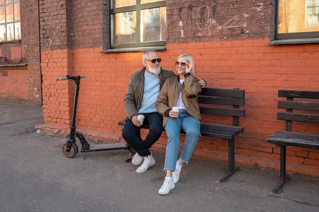 Casal sênior de tiro completo sentado no banco