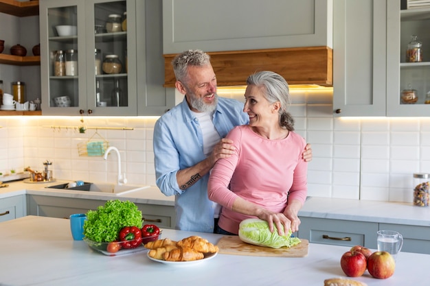 Casal sênior em tiro médio na cozinha