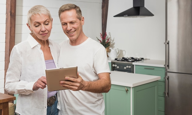 Foto grátis casal sênior segurando um tablet