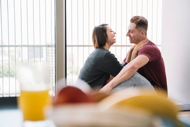 Casal sentado e rindo em casa