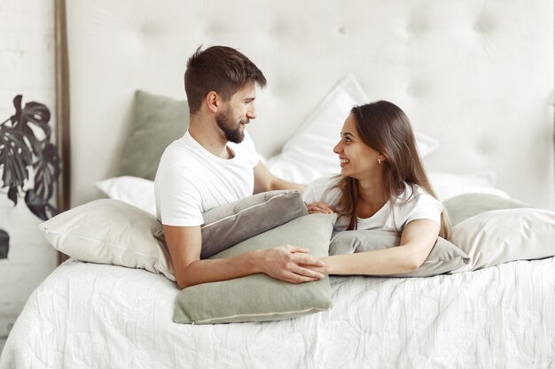 Casal sentado em uma cama em um quarto