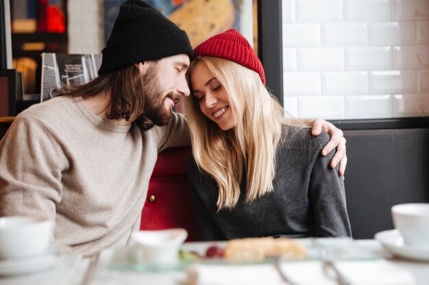 Casal sentado juntos e abraçando no café