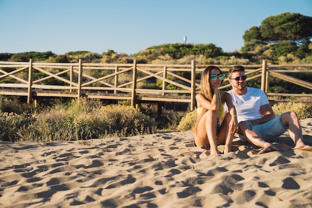 Foto grátis casal sentado na areia