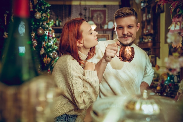 Casal sorridente à procura de decoração para casa e presentes de Natal em uma loja de artigos domésticos