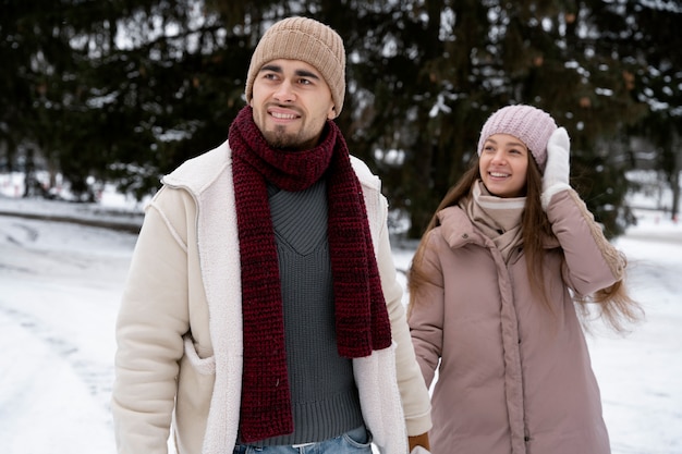 Casal sorridente com foto média no inverno Foto gratuita