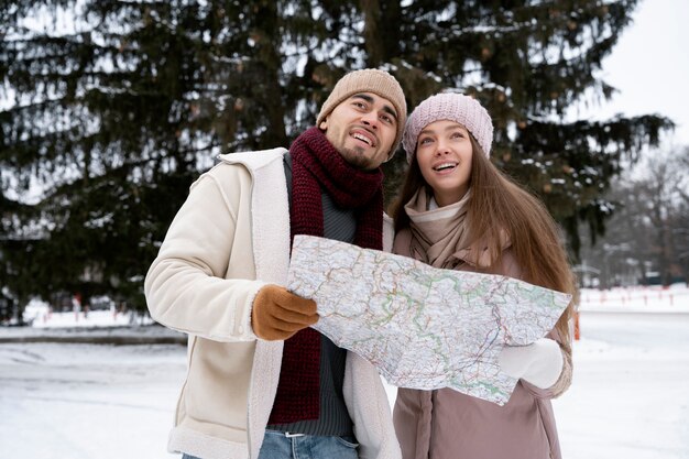 Casal sorridente com foto média segurando mapa