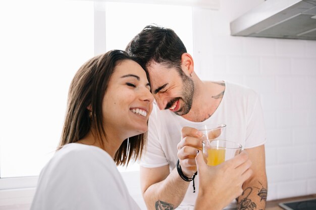 Casal sorridente com suco tocando fraldas