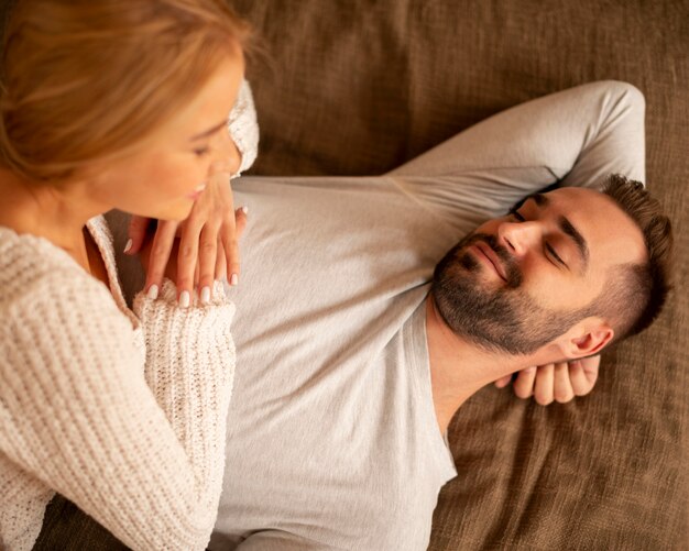 Casal sorridente com vista superior dentro de casa