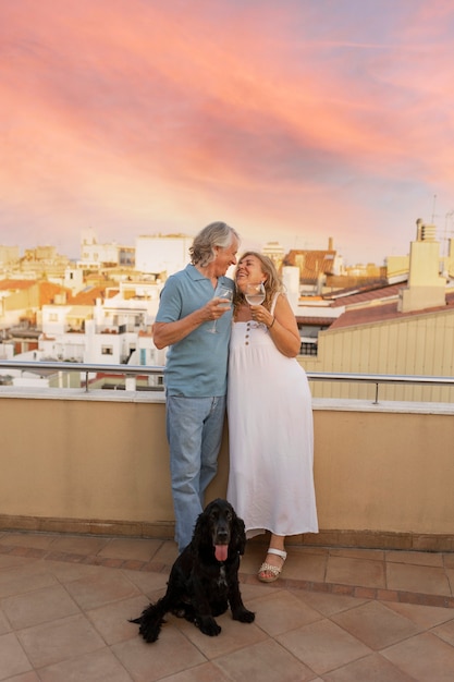 Casal sorridente de tiro completo com bebidas ao ar livre