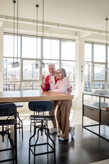 Foto grátis casal sorridente de tiro completo com bebidas