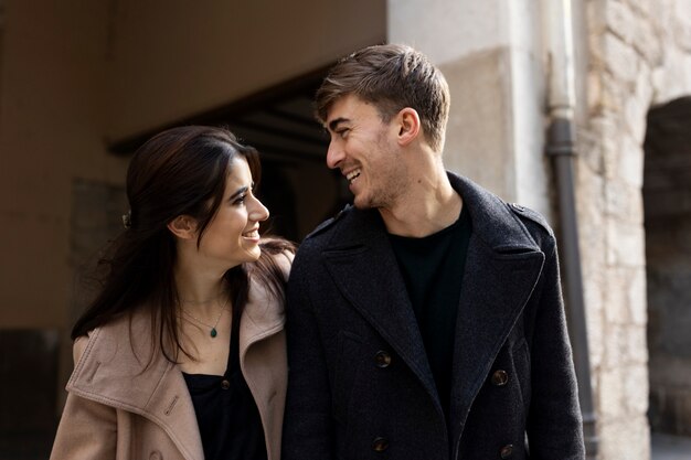 Casal sorridente de tiro médio caminhando juntos