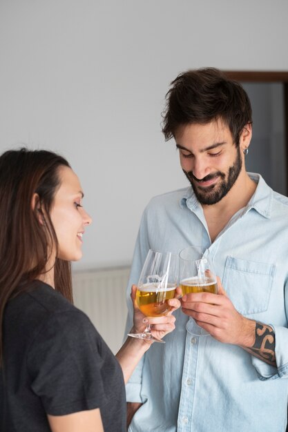 Casal sorridente de tiro médio com bebidas