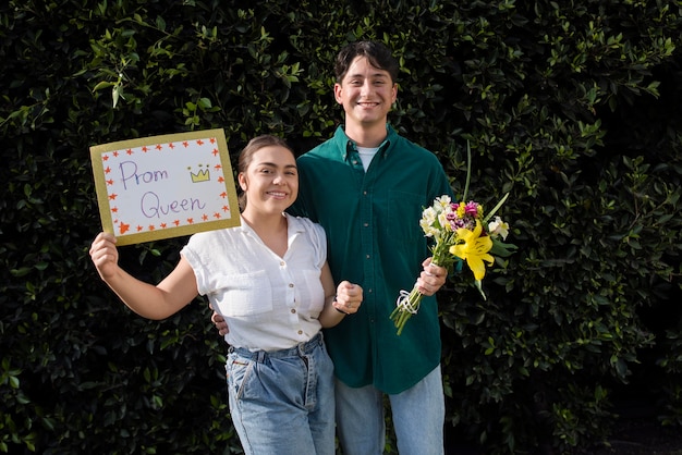 Casal sorridente de tiro médio com flores