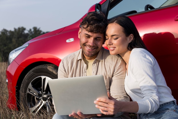 Casal sorridente de tiro médio com laptop