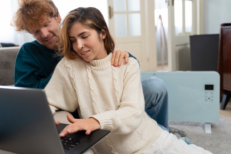 Foto grátis casal sorridente de tiro médio com laptop