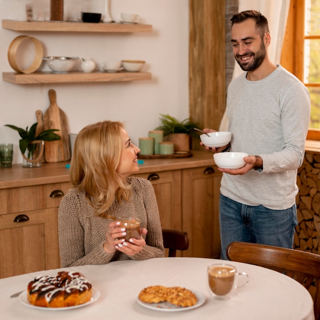 Casal sorridente de tiro médio na cozinha