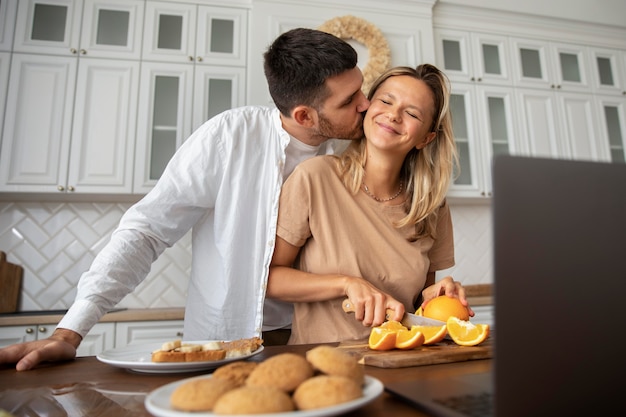 Casal sorridente de tiro médio na cozinha