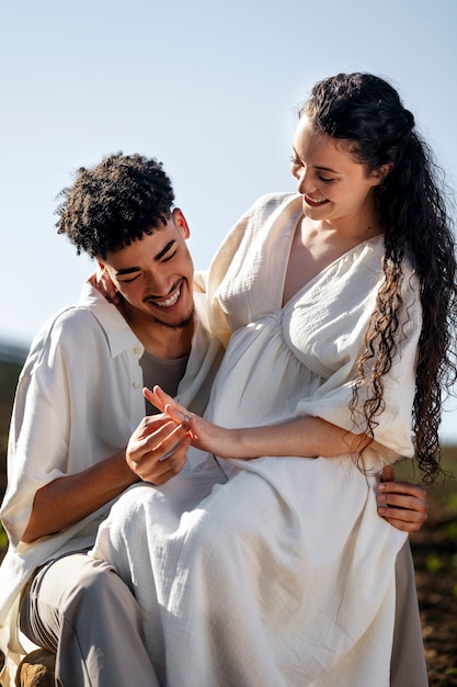 Casal sorridente em foto média ao ar livre