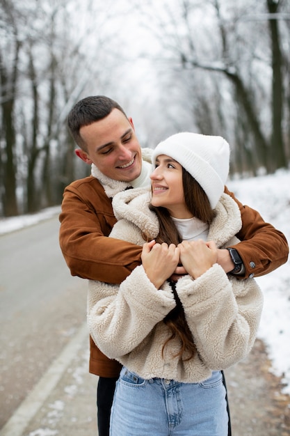 Casal sorridente em foto média do lado de fora