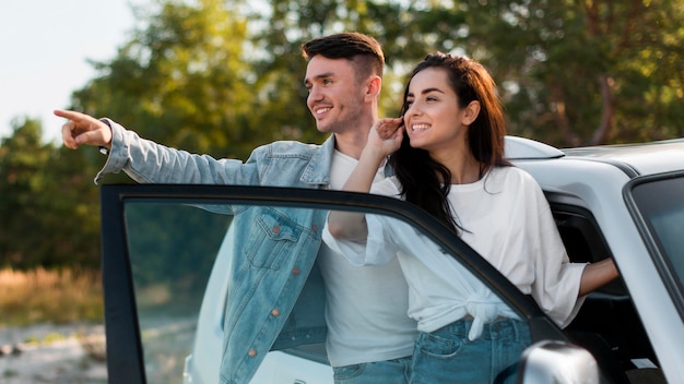 Casal sorridente em foto média olhando para longe