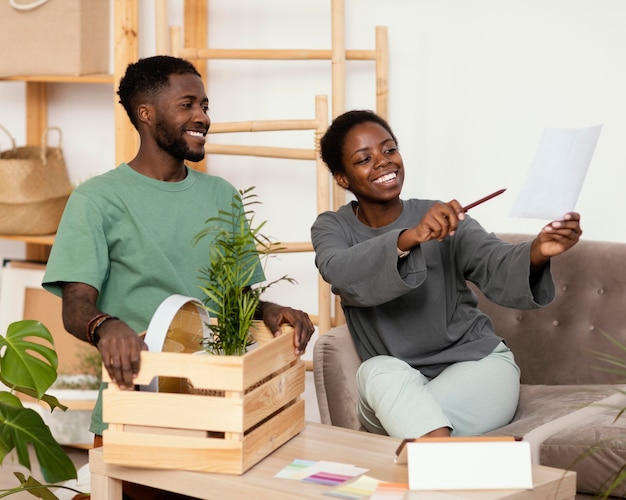 Casal sorridente no sofá planejando redecorar a casa