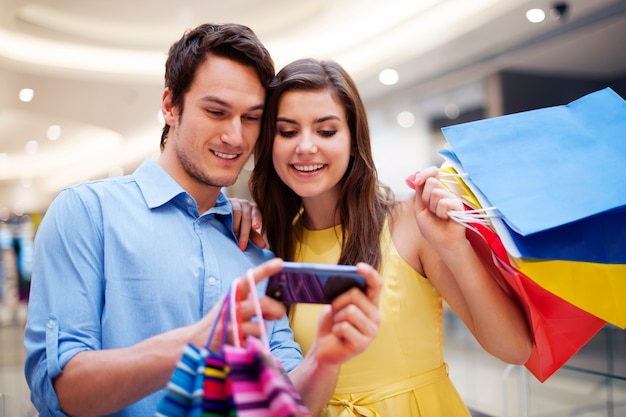 Casal sorridente, olhando para o celular