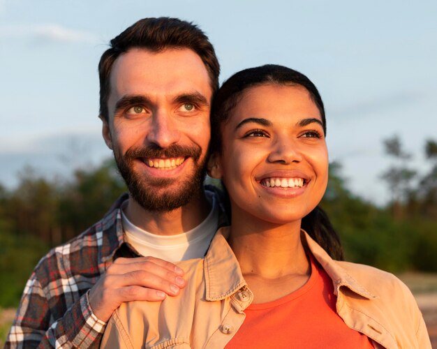 Casal sorridente olhando um lindo pôr do sol