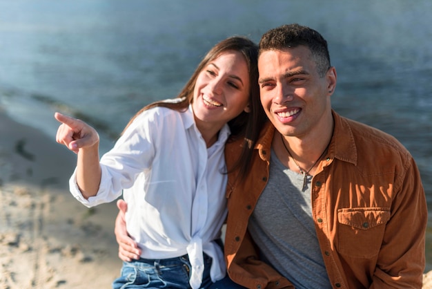 Casal sorridente passando um tempo juntos na praia