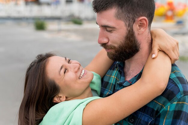 Casal sorridente se abraçando ao ar livre